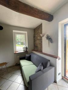 - un salon avec un canapé et une fenêtre dans l'établissement Casa Margot, à Garlenda