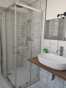 a bathroom with a sink and a glass shower at Casa Ilanga in Cannero Riviera