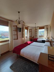 a bedroom with two beds and a large window at Hotel Rural Foncubierta in Soto del Barco
