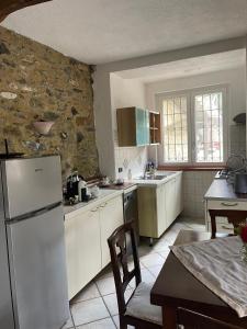 - une cuisine avec des appareils blancs et un mur en pierre dans l'établissement Casa Margot, à Garlenda