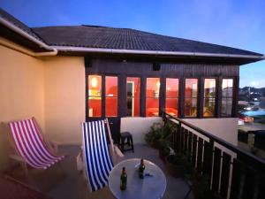 un patio con 2 sedie e un tavolo sul balcone di Hostal Kuyen a Pichilemu