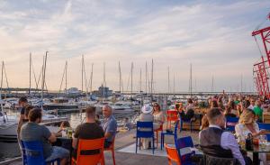 a group of people sitting at tables at a marina at Kalamaja Park Apartment fast net 150 G, bath in Tallinn