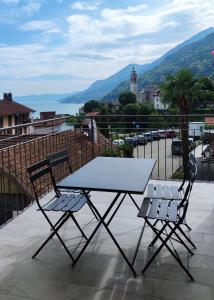 une table et deux chaises assises sur un balcon dans l'établissement Casa Ilanga, à Cannero Riviera