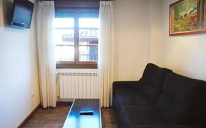 a living room with a couch and a table and a window at Hotel Rural Foncubierta in Soto del Barco