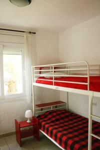sypialnia z 2 łóżkami piętrowymi i oknem w obiekcie Mas Mundo - 4 Ferienhäuser in Calonge / Girona w mieście Girona