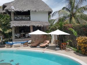 a resort with a swimming pool and a building at Boutique Hotel Nyumbani Tembo in Watamu