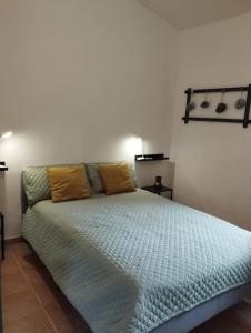 a bedroom with a large bed with yellow pillows on it at Hideaway @ The Orchard in Alcudia de Monteagud
