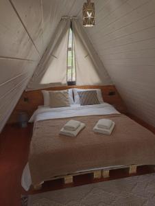 a bed in a tent with two towels on it at Cottage Toladi in Stepantsminda