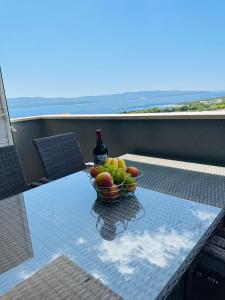 a bowl of fruit and a bottle of wine on a table at La Mer 1 in Bol