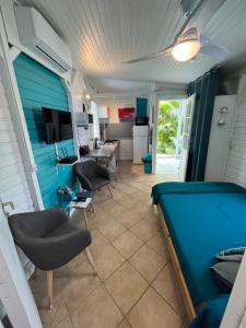 Bungalow avec piscine في سانت-ماري: غرفة معيشة بجدران زرقاء وأريكة وكراسي