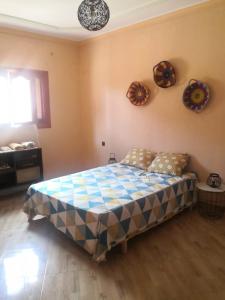 a bedroom with a bed and plates on the wall at Family house 2 bedrooms, 2 sdb, near Center of Nador & Airport in Selouane