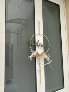 una señal de bienvenida en una puerta de cristal con un arco en Casa Vacanze Viale Miramare 31- Delizioso mini loft industrial, en Trieste