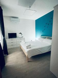 1 dormitorio con 1 cama blanca y TV en Casa Vacanze Viale Miramare 31- Delizioso mini loft industrial, en Trieste