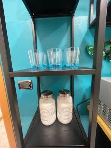 dos frascos de cristal sentados en un estante en un armario en Casa Vacanze Viale Miramare 31- Delizioso mini loft industrial, en Trieste