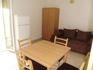 a living room with a wooden table and a couch at Apartments Roko in Rogoznica