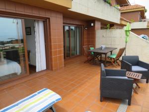 Un patio con sillas y una mesa en un edificio. en Vistas magnificas Islas Atlanticas, en Baiona