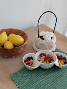 une table en bois avec des bols de nourriture et des bols de fruits dans l'établissement More, à Vodice