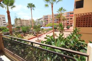 a balcony of a condo with palm trees and buildings at Trilocale moderno e centrale a Los Cristianos in Los Cristianos