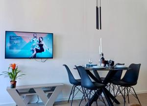 a dining room with a table and a tv on the wall at Villa V in Rijeka