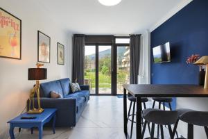 - un salon avec un canapé bleu et une table dans l'établissement Dolce Vita Baveno - By Impero House, à Baveno