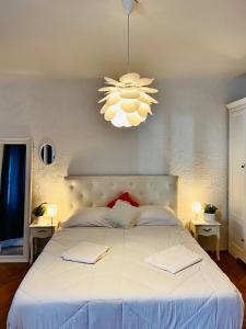 a bedroom with a large white bed with a chandelier at City Square Apartment in Poreč