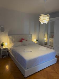 a bedroom with a large white bed with a chandelier at City Square Apartment in Poreč