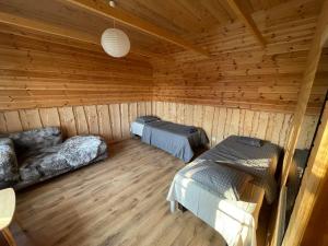 a room with two beds in a wooden cabin at JUST Lodges in Orissaare