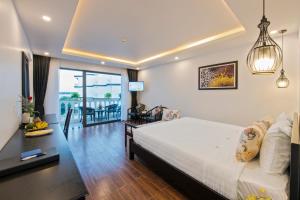 a bedroom with a large bed and a living room at Gem Riverside Hotel Hoi An in Hoi An