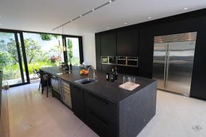 una cucina con armadi neri e piano di lavoro nero di Breathtaking Villa w Pool & Sauna Near the Beach by Sea N' Rent a Herzelia