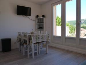 een eetkamer met een tafel, stoelen en een televisie bij La Saluade, pour curistes ou vacanciers in Gréoux-les-Bains