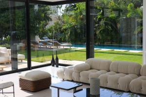 un soggiorno con divano bianco e una grande finestra di Breathtaking Villa w Pool & Sauna Near the Beach by Sea N' Rent a Herzelia