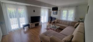 ein Wohnzimmer mit einem Sofa und einem Flachbild-TV in der Unterkunft Villa Longina in Ljubuški