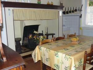 une salle à manger avec une table et une cheminée dans l'établissement Gîte les Marronniers, 