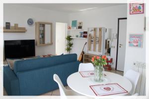 uma sala de estar com um sofá azul e uma mesa em Your Place By The Lake - near Leonardo Academy, MXP em Sesto Calende