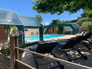 - un groupe de chaises assises à côté de la piscine dans l'établissement Residence Melody, à Saint-Rémy-de-Provence