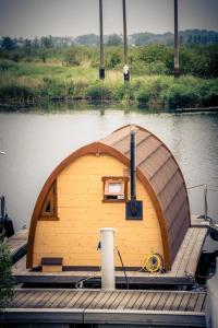 a small boat on a dock in the water at Schwimmpod an der Peene in Anklam
