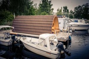 zwei Boote sind an einem Dock im Wasser angedockt in der Unterkunft Schwimmpod an der Peene in Anklam