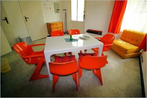 sala de estar con mesa y sillas rojas en DDR Bungalow direkt am Strand auf Rügen en Dranske