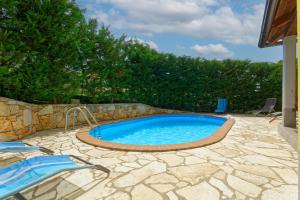 een zwembad in een achtertuin met een stenen patio bij Holiday Home Sunny Twins in Grožnjan
