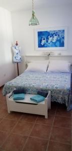 SavaにあるCasa Vacanza La Cravaのベッドルーム(白と青のシーツが入った白いベッド付)