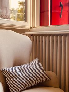 un oreiller assis sur une chaise à côté d'une fenêtre dans l'établissement Casa liberty tra i vigneti - 2 camere da letto, à Conselve