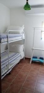 SavaにあるCasa Vacanza La Cravaのタイルフロアのドミトリールームの二段ベッド2台分です。