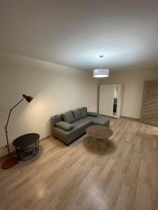 sala de estar con sofá y mesa en 1 kambario butas self check in, en Šiauliai