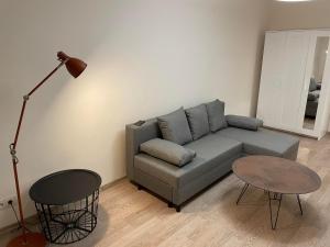 sala de estar con sofá y mesa en 1 kambario butas self check in, en Šiauliai