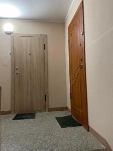 Habitación vacía con 2 puertas de madera y alfombra en 1 kambario butas self check in, en Šiauliai