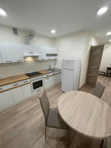 cocina con mesa, mesa y sillas en 1 kambario butas self check in, en Šiauliai