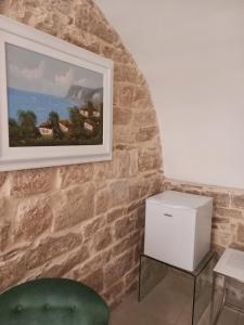 a living room with a painting on the wall and a green chair at Suite Duomo Trani 8 in Trani