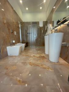a bathroom with three sinks and two toilets at 4heavens_naples in Naples