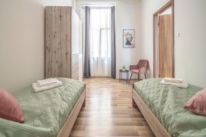 um quarto com duas camas e uma cadeira em Chameleon Apartment Budapest em Budapeste