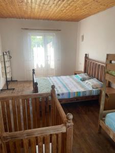 um quarto com uma cama de madeira e uma janela em Leto land Guest House em Pizunda